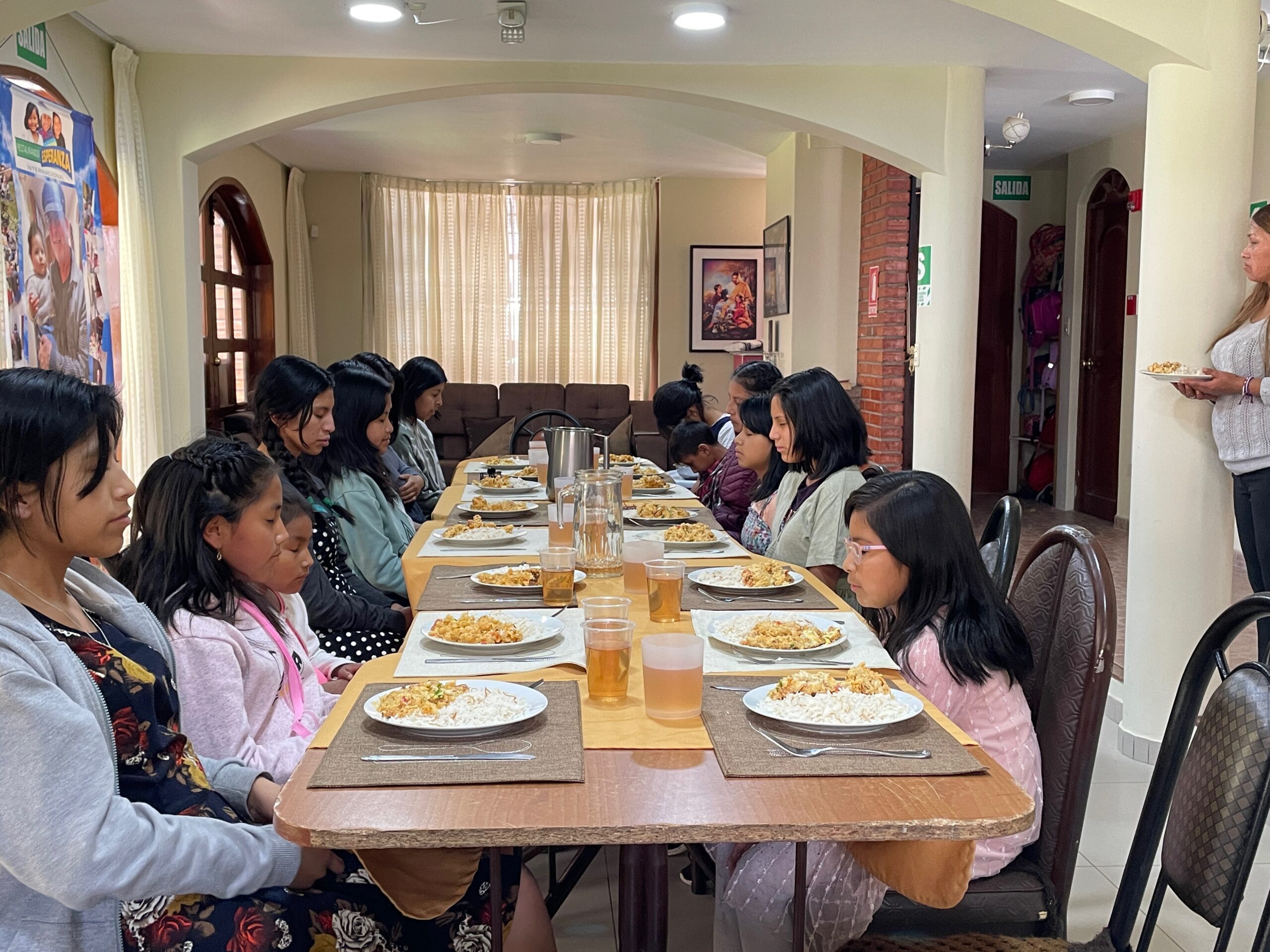 A young girl enjoying a meal at home, surrounded by warm and soft lighting.